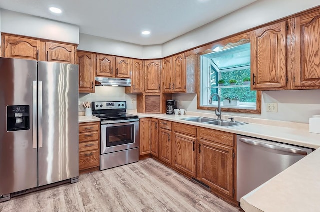 4900 Hodgson Rd, Connection, Shoreview, MN 55126 - kitchen featuring stainless steel appliances, under cabinet range hood, brown cabinets, light wood-style floors, and light countertops
