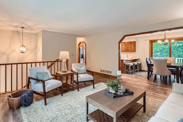 4900 Hodgson Rd, Connection, Shoreview, MN 55126 - living room featuring light wood-style floors, arched walkways, and a chandelier