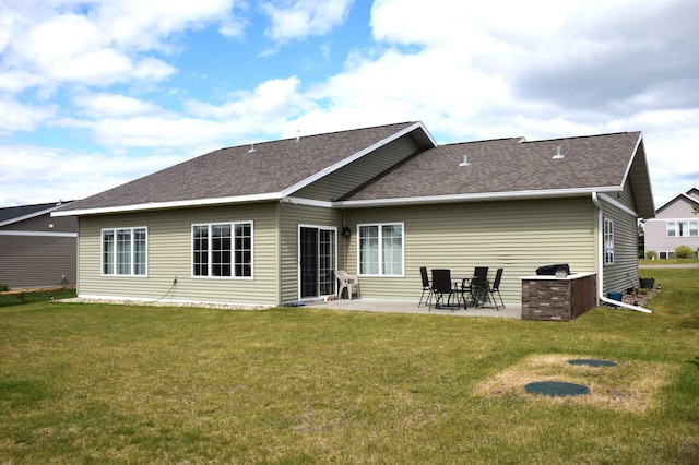 2008 Whiting Rd NW Unit 10, Bemidji, MN 56601 - back of property featuring a patio, a lawn, and roof with shingles