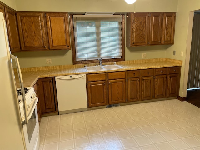 7765 Woodpark Blvd, Woodbury, MN 55125 - kitchen with white appliances, a sink, light countertops, and brown cabinets