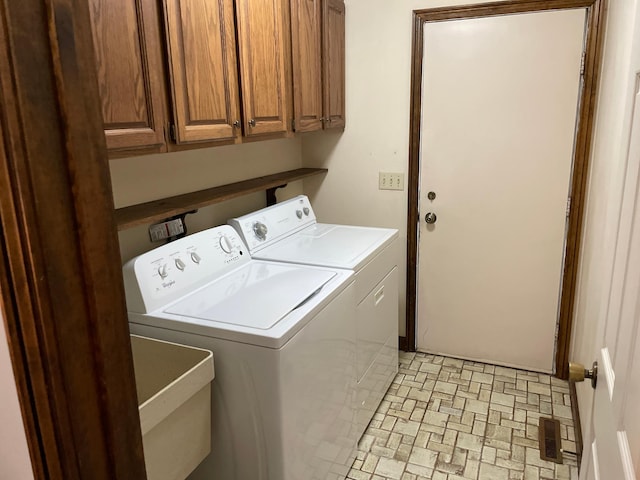 7765 Woodpark Blvd, Woodbury, MN 55125 - laundry area with washer and clothes dryer, cabinet space, and brick patterned floors