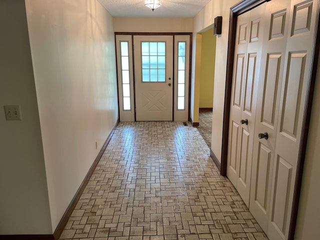 7765 Woodpark Blvd, Woodbury, MN 55125 - entryway featuring baseboards and a textured ceiling