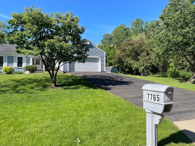 7765 Woodpark Blvd, Woodbury, MN 55125 - view of property hidden behind natural elements with driveway, a front yard, and a garage