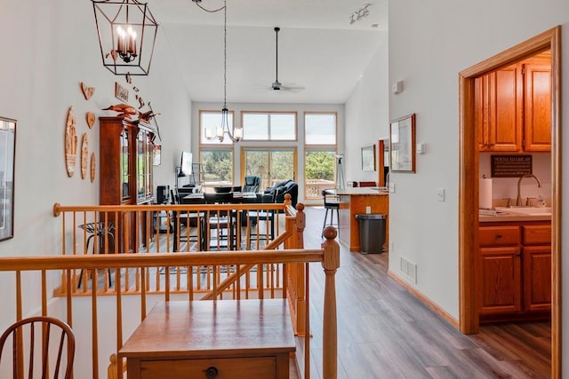 1439 Summit Shores Dr, Burnsville, MN 55306 - dining space with light wood-type flooring, a chandelier, high vaulted ceiling, a ceiling fan, and baseboards