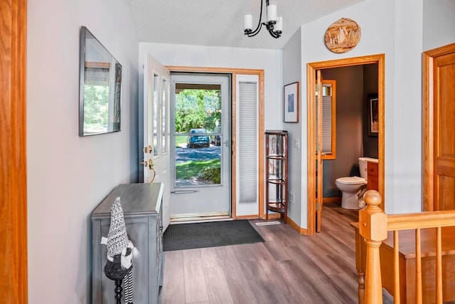 1439 Summit Shores Dr, Burnsville, MN 55306 - entrance foyer with wood finished floors, lofted ceiling, baseboards, and a chandelier