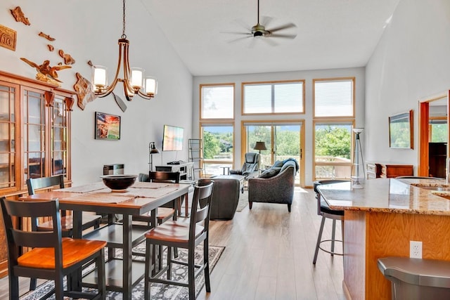 1439 Summit Shores Dr, Burnsville, MN 55306 - dining area featuring high vaulted ceiling, light wood-type flooring, a chandelier, and a ceiling fan