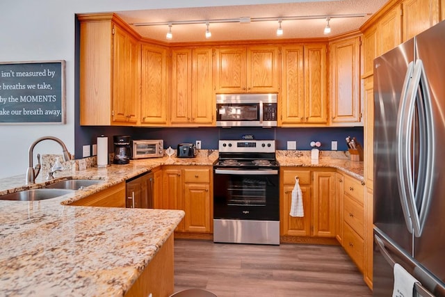 1439 Summit Shores Dr, Burnsville, MN 55306 - kitchen with appliances with stainless steel finishes, a sink, track lighting, and light stone countertops