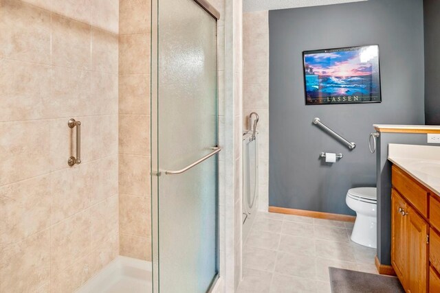 1439 Summit Shores Dr, Burnsville, MN 55306 - bathroom with vanity, a stall shower, tile patterned floors, toilet, and baseboards