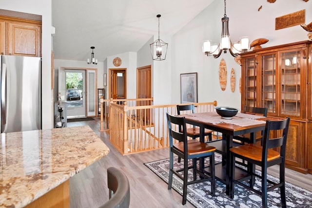 1439 Summit Shores Dr, Burnsville, MN 55306 - dining room featuring a chandelier, vaulted ceiling, and light wood-style floors
