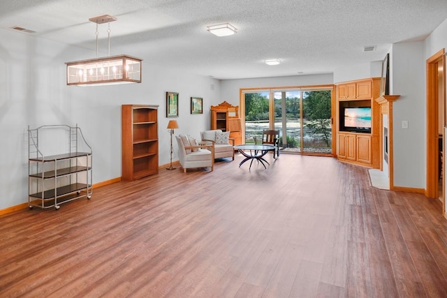 1439 Summit Shores Dr, Burnsville, MN 55306 - living area featuring wood finished floors, baseboards, and a textured ceiling