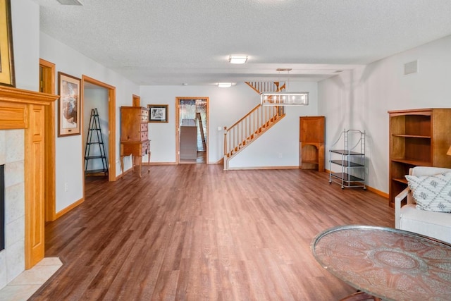 1439 Summit Shores Dr, Burnsville, MN 55306 - unfurnished living room featuring wood finished floors, stairs, a fireplace, a textured ceiling, and baseboards