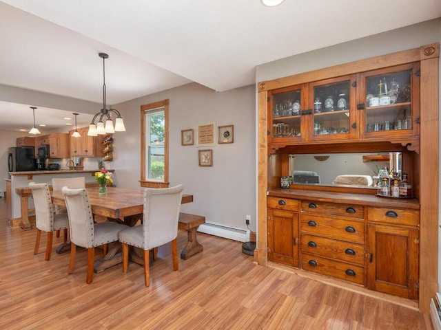 306 Benton St W, Cologne, MN 55322 - dining area featuring a baseboard heating unit, light wood-style floors, and baseboards
