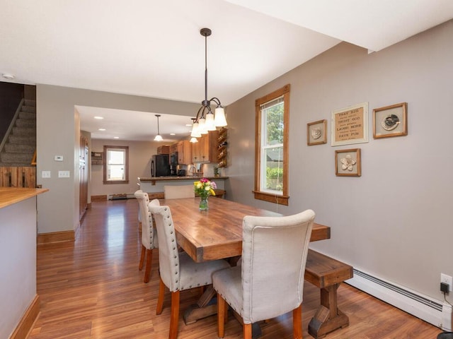 306 Benton St W, Cologne, MN 55322 - dining area with baseboard heating, stairs, light wood-style floors, recessed lighting, and baseboards