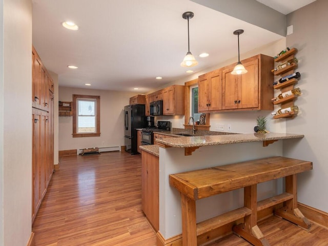 306 Benton St W, Cologne, MN 55322 - kitchen with black appliances, a sink, a peninsula, light wood-style flooring, and baseboards