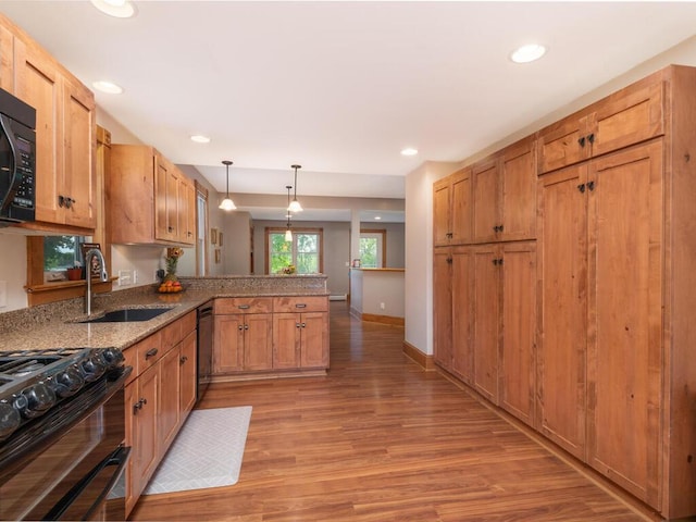 306 Benton St W, Cologne, MN 55322 - kitchen featuring a sink, a peninsula, light wood-style floors, black appliances, and pendant lighting