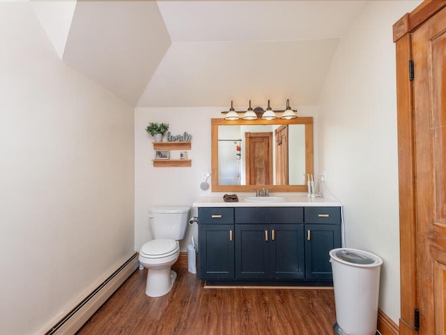 306 Benton St W, Cologne, MN 55322 - bathroom featuring a baseboard heating unit, vanity, toilet, wood finished floors, and vaulted ceiling
