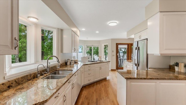 7420 Long Lake Rd, Dovre Twp, MN 56201 - kitchen with a sink, freestanding refrigerator, a peninsula, light wood-type flooring, and plenty of natural light
