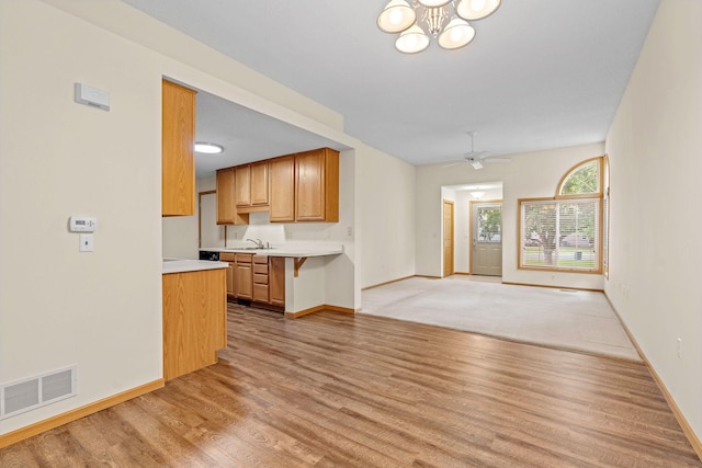 10767 Tamarack Cir NW, Coon Rapids, MN 55433 - unfurnished living room featuring light wood-type flooring, ceiling fan, and a chandelier