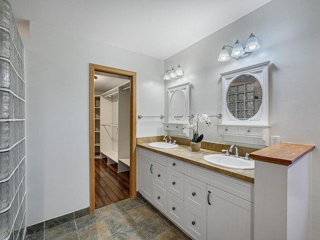 1396 Palace Ave, Saint Paul, MN 55105 - bathroom featuring double vanity, stone finish floors, and a spacious closet