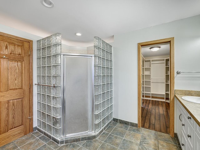 1396 Palace Ave, Saint Paul, MN 55105 - bathroom with vanity, a shower stall, a spacious closet, stone finish flooring, and baseboards