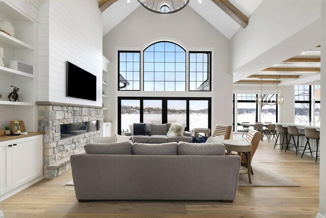 5283 Frost Point Cir SE, Prior Lake, MN 55372 - living room featuring high vaulted ceiling, beamed ceiling, a fireplace, light wood-type flooring, and a chandelier