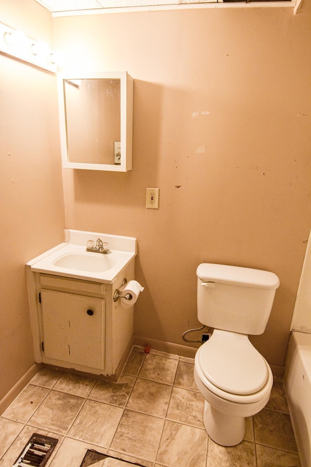 715 8th St E, Thief River Falls, MN 56701 - bathroom featuring toilet, vanity, and baseboards