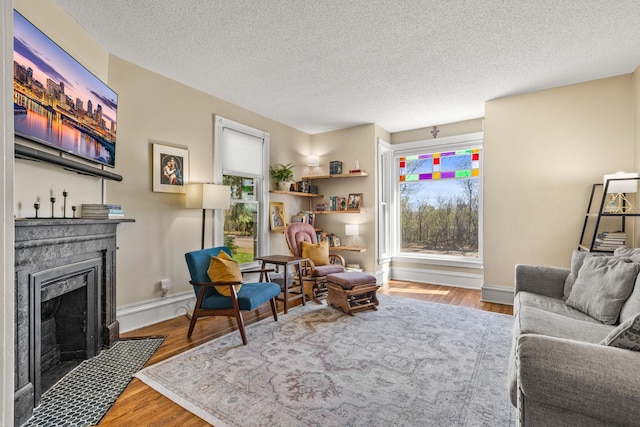 1415 Wynne Ave, Saint Paul, MN 55108 - living room with a fireplace with flush hearth, wood finished floors, a textured ceiling, and baseboards