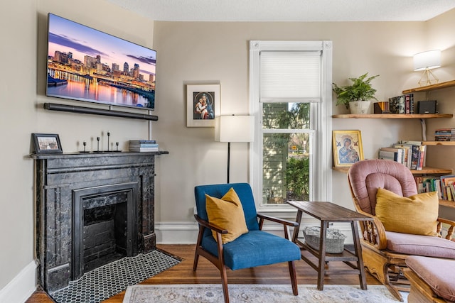 1415 Wynne Ave, Saint Paul, MN 55108 - living area featuring wood finished floors, a fireplace with flush hearth, and baseboards