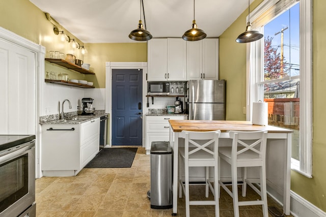 1415 Wynne Ave, Saint Paul, MN 55108 - kitchen with stainless steel appliances, a sink, open shelves, decorative backsplash, and white cabinets