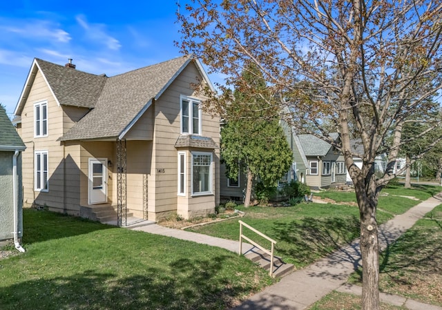 1415 Wynne Ave, Saint Paul, MN 55108 - view of front of home with a shingled roof, a front lawn, entry steps, and a chimney