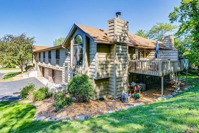 3948 Orchid Ln N, Plymouth, MN 55446 - view of home's exterior with a chimney, a wooden deck, an attached garage, and asphalt driveway