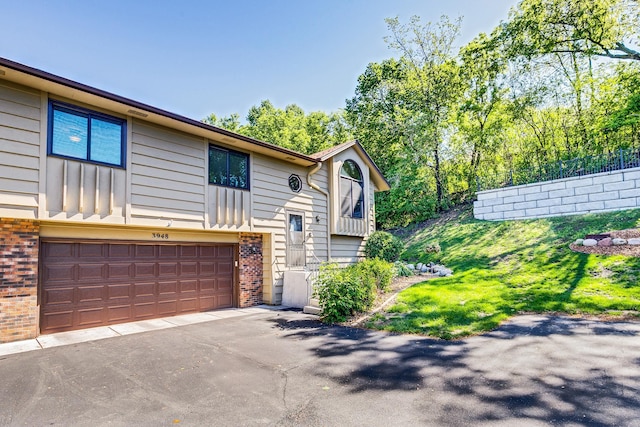 3948 Orchid Ln N, Plymouth, MN 55446 - split foyer home featuring brick siding, an attached garage, asphalt driveway, and board and batten siding