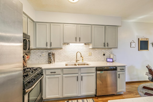 3948 Orchid Ln N, Plymouth, MN 55446 - kitchen with appliances with stainless steel finishes, a sink, light countertops, and gray cabinets