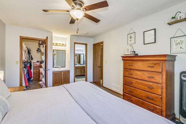3948 Orchid Ln N, Plymouth, MN 55446 - bedroom featuring a walk in closet, a closet, ensuite bath, a ceiling fan, and carpet flooring