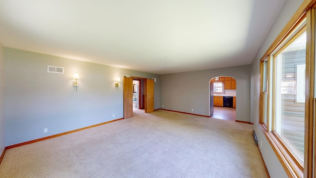 706 19th St, Albert Lea, MN 56007 - unfurnished room featuring arched walkways, light carpet, and baseboards