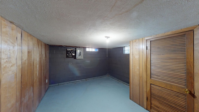 706 19th St, Albert Lea, MN 56007 - basement featuring concrete block wall, wood walls, electric panel, and a textured ceiling
