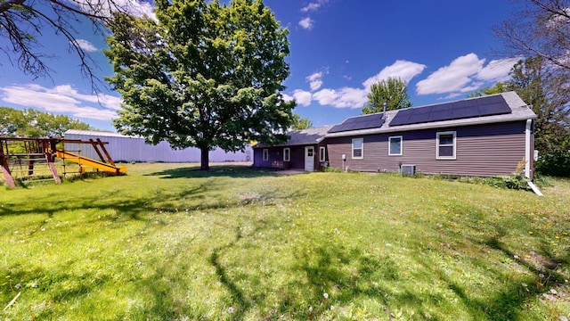 706 19th St, Albert Lea, MN 56007 - rear view of house with a playground, a yard, and roof mounted solar panels