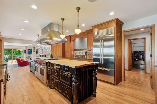 4080 Lotus Dr, Minnetrista, MN 55331 - kitchen with high quality appliances, island exhaust hood, washer / dryer, butcher block counters, and decorative backsplash