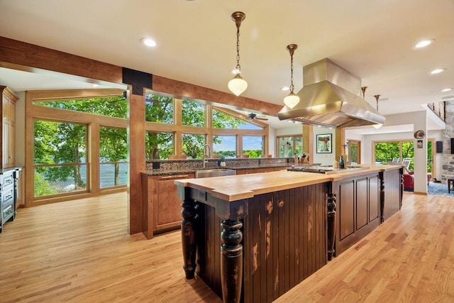 4080 Lotus Dr, Minnetrista, MN 55331 - kitchen with butcher block countertops, island exhaust hood, light wood finished floors, stainless steel gas stovetop, and a large island
