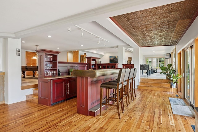 4080 Lotus Dr, Minnetrista, MN 55331 - kitchen with light wood-style flooring, open shelves, reddish brown cabinets, and a breakfast bar