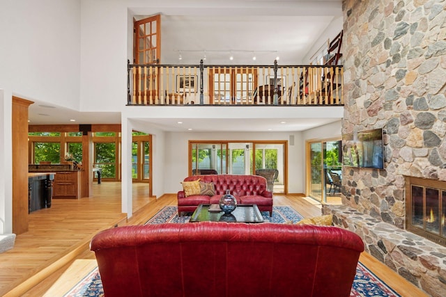 4080 Lotus Dr, Minnetrista, MN 55331 - living room with wood finished floors, a fireplace, track lighting, and a high ceiling
