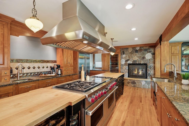 4080 Lotus Dr, Minnetrista, MN 55331 - kitchen featuring island exhaust hood, wooden counters, double oven range, a sink, and light wood-style floors