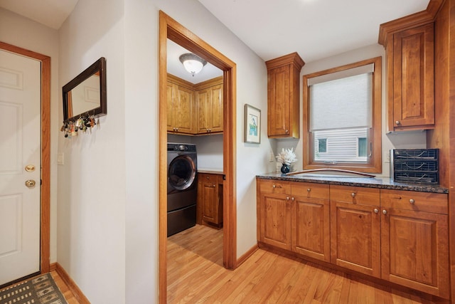 4080 Lotus Dr, Minnetrista, MN 55331 - laundry area featuring cabinet space, washer / clothes dryer, light wood-style flooring, and baseboards