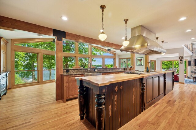 4080 Lotus Dr, Minnetrista, MN 55331 - kitchen featuring wood counters, island range hood, light wood-style floors, stainless steel gas cooktop, and a large island