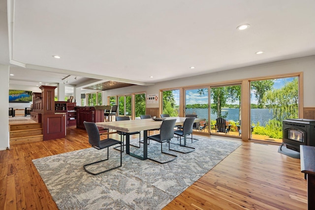 4080 Lotus Dr, Minnetrista, MN 55331 - dining space with ornate columns, a wood stove, light wood-style flooring, recessed lighting, and a water view