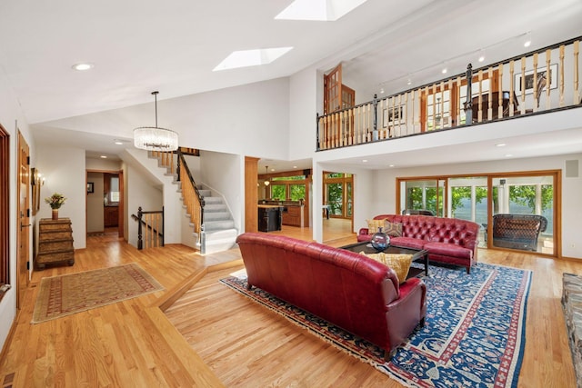 4080 Lotus Dr, Minnetrista, MN 55331 - living room with wood finished floors, stairway, a skylight, lofted ceiling, and a chandelier