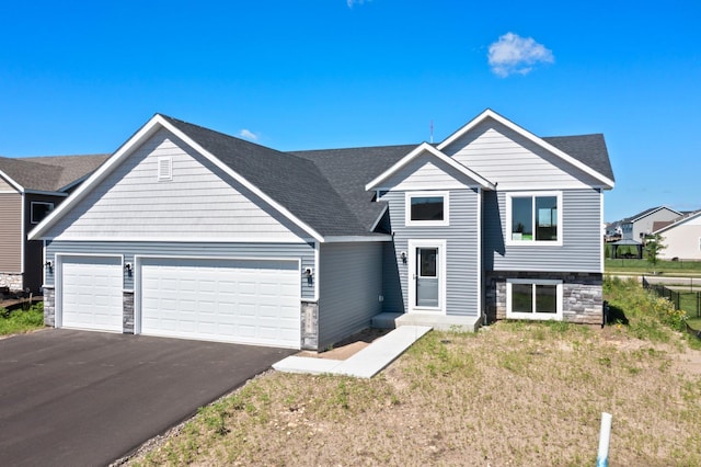 2135 Violet Ln, Faribault, MN 55021 - view of front of home with stone siding, an attached garage, and asphalt driveway