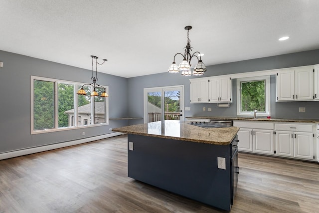 1901 Lexington Ave S, Mendota Heights, MN 55118 - kitchen with a chandelier, a sink, a kitchen island, white cabinetry, and baseboard heating