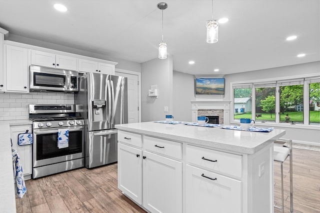 11508 Georgia Ave N, Champlin, MN 55316 - kitchen with stainless steel appliances, recessed lighting, light wood-style floors, decorative light fixtures, and a kitchen island