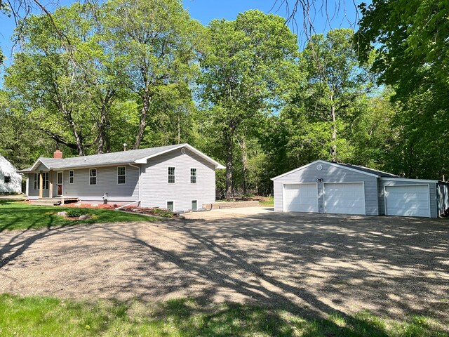 10306 Hemlock St NW, Annandale, MN 55302 - view of home's exterior featuring a detached garage, an outdoor structure, a chimney, and view of scattered trees